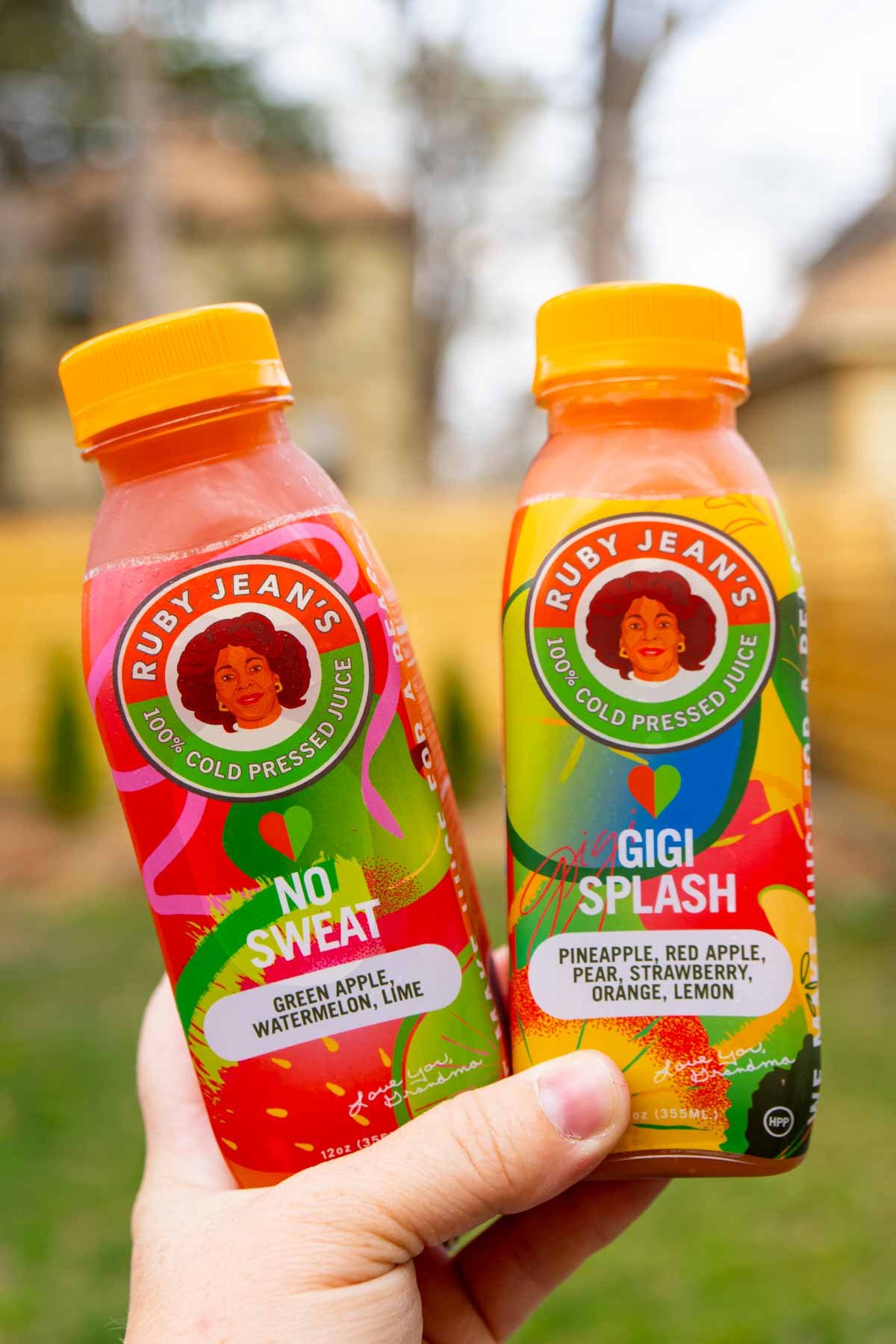 hand holding two bottles of Ruby Jean Juicery Juice