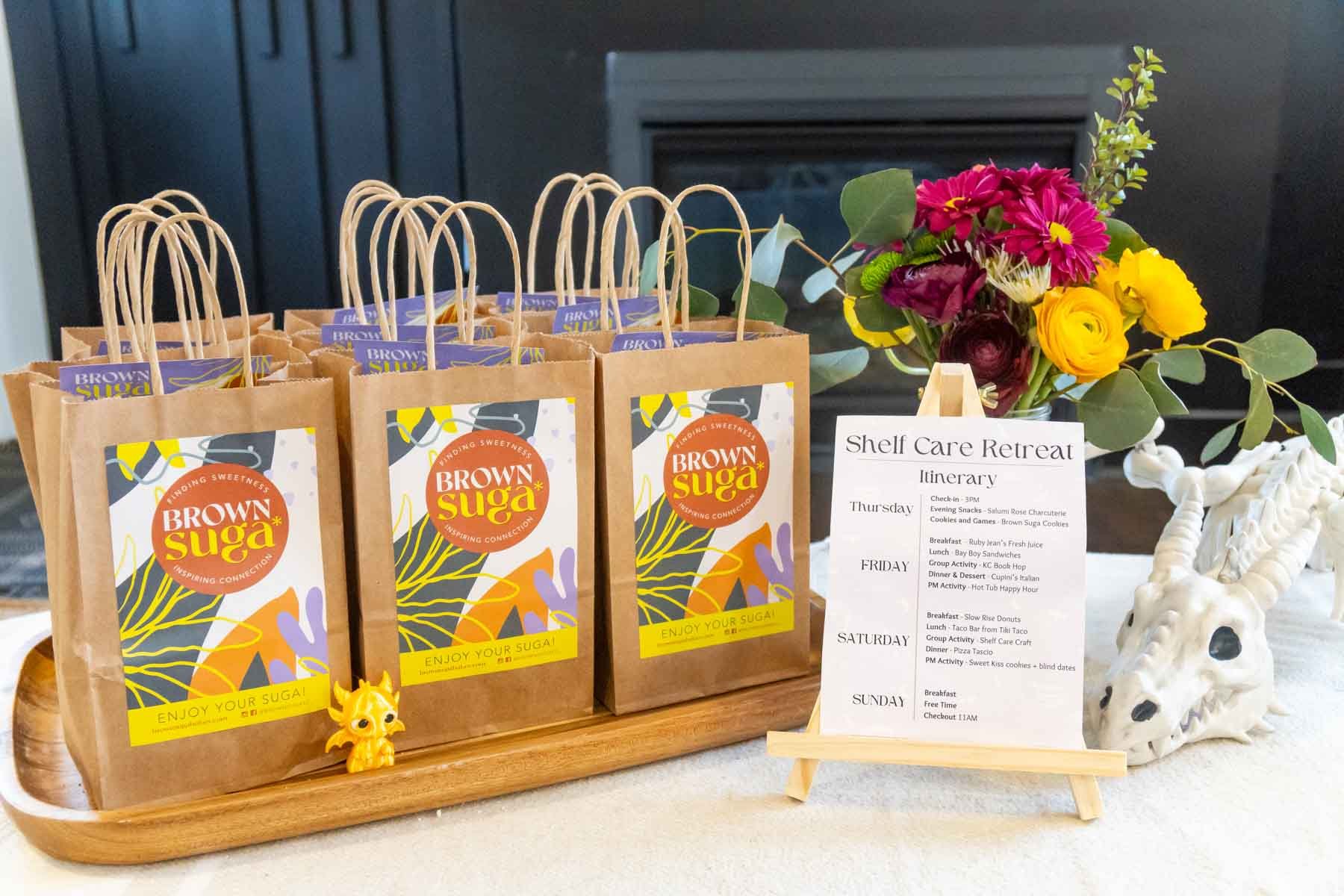 table set with a book retreat agenda, bags, flowers, and dragons