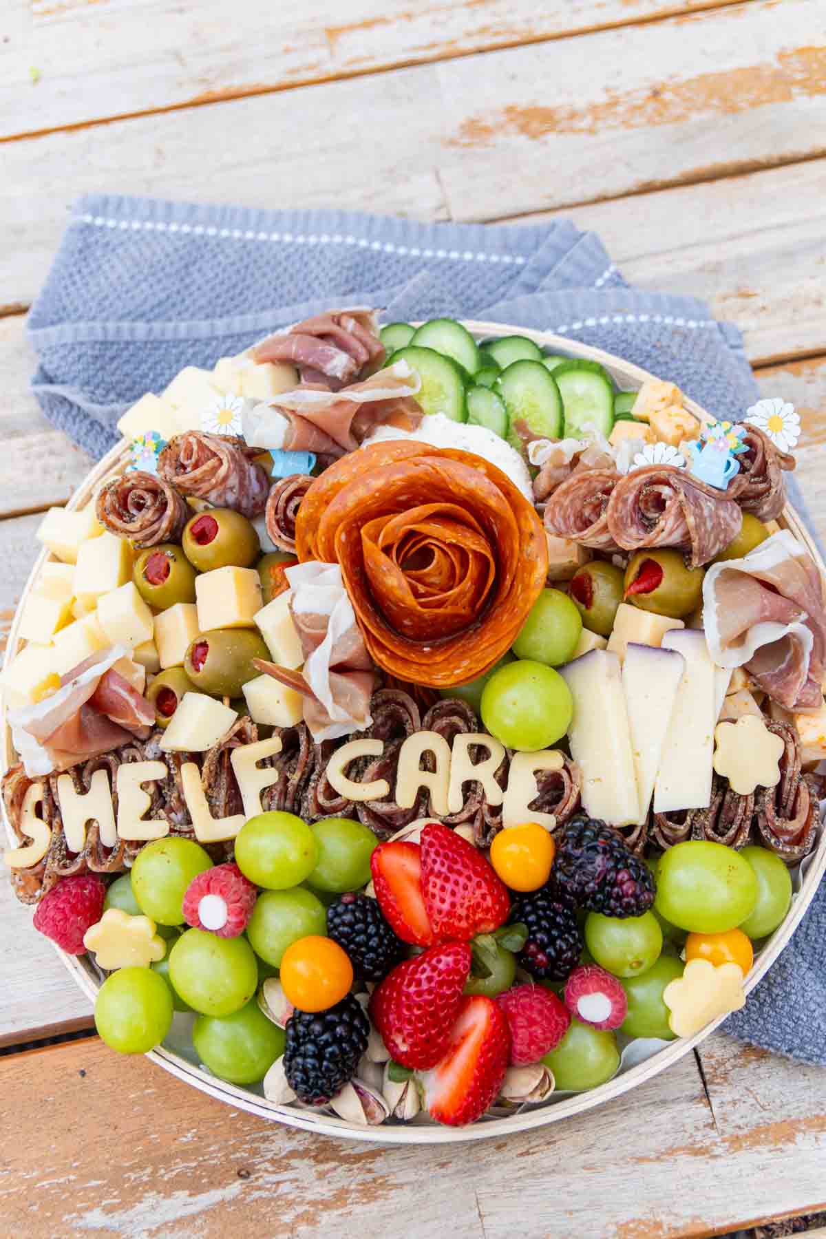 charcuterie board with cheese letters spelling shelf care