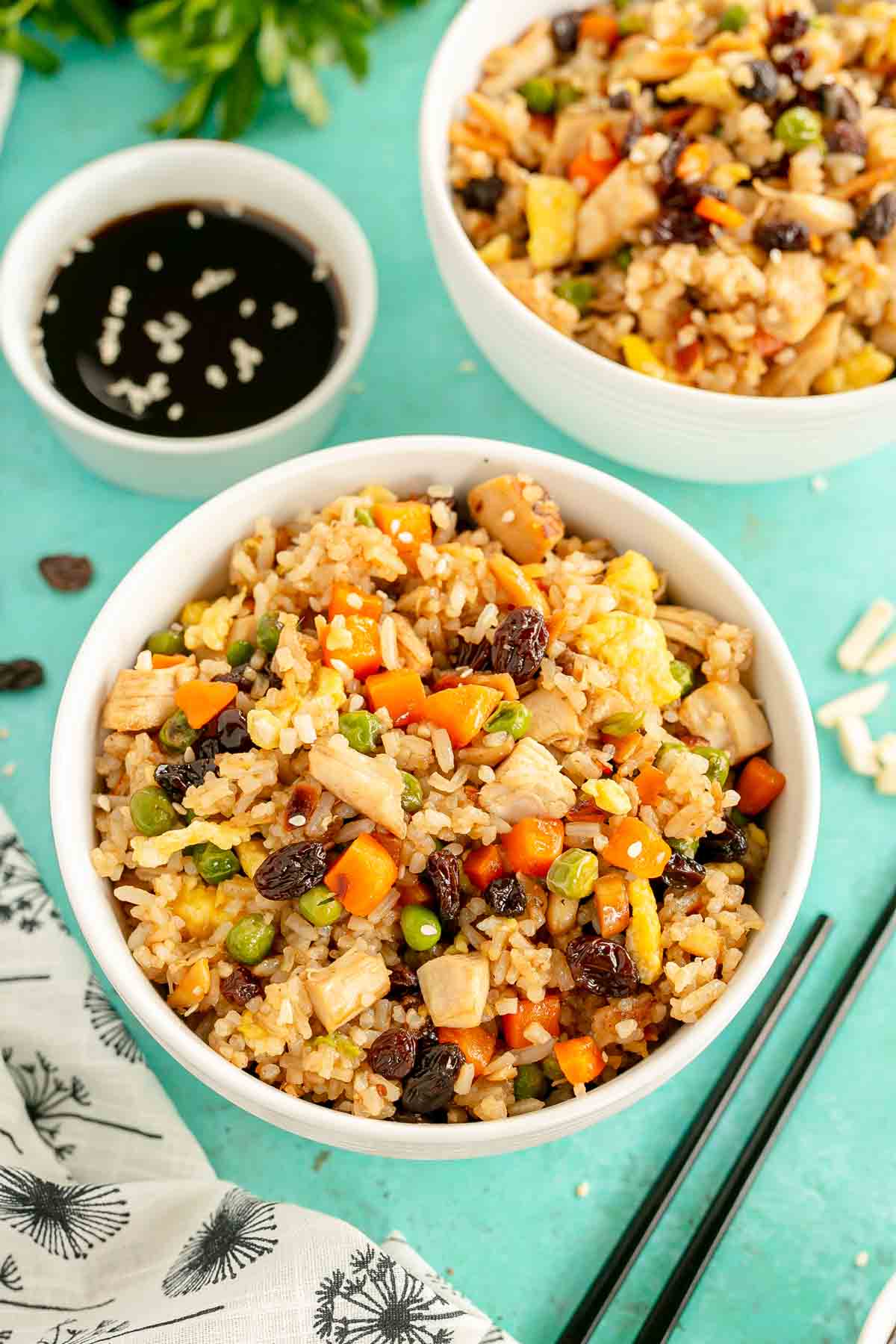 White bowl with rotisserie chicken fried rice and chopsticks next to it