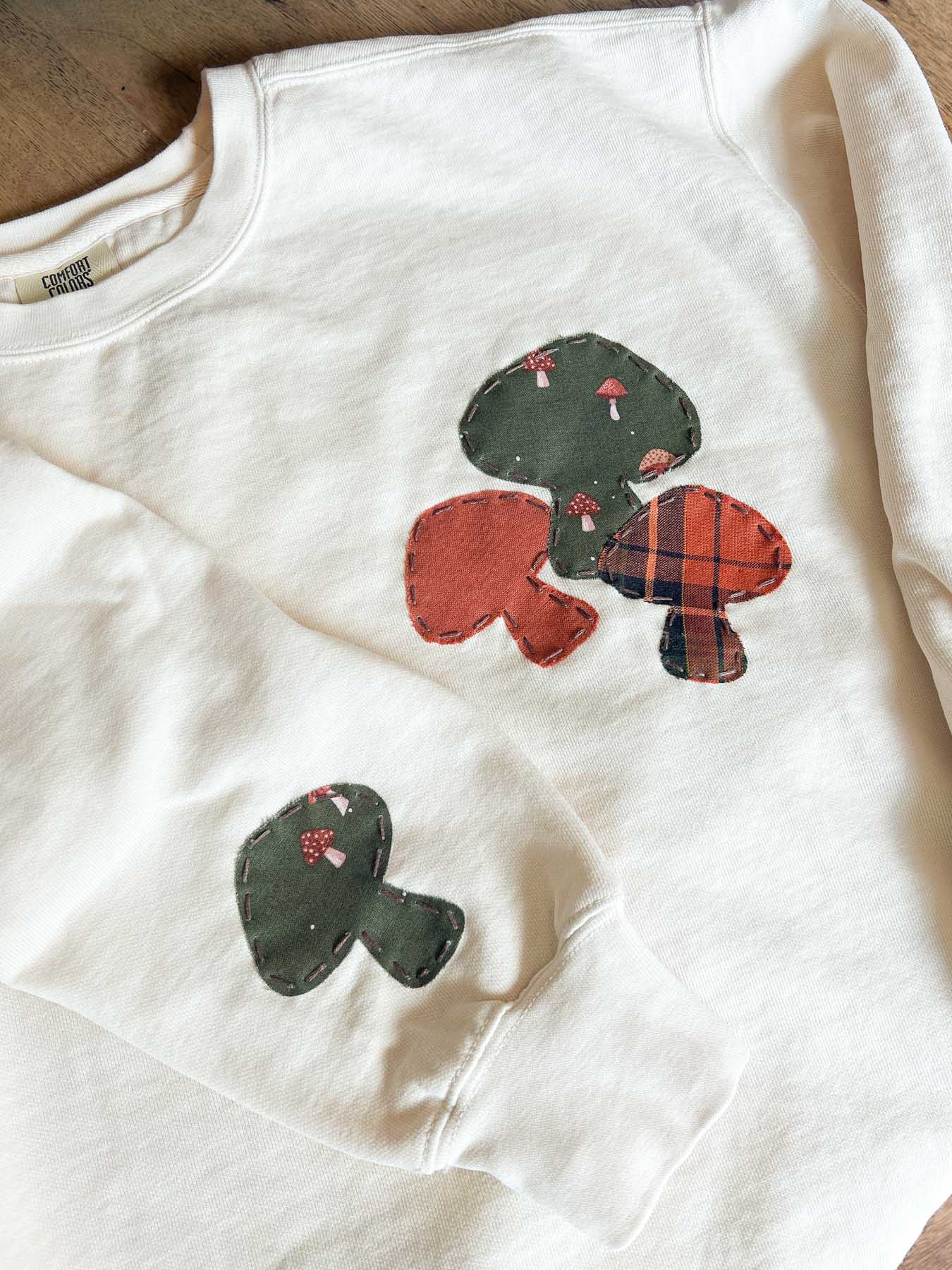 cream sweatshirt with embroidered mushrooms