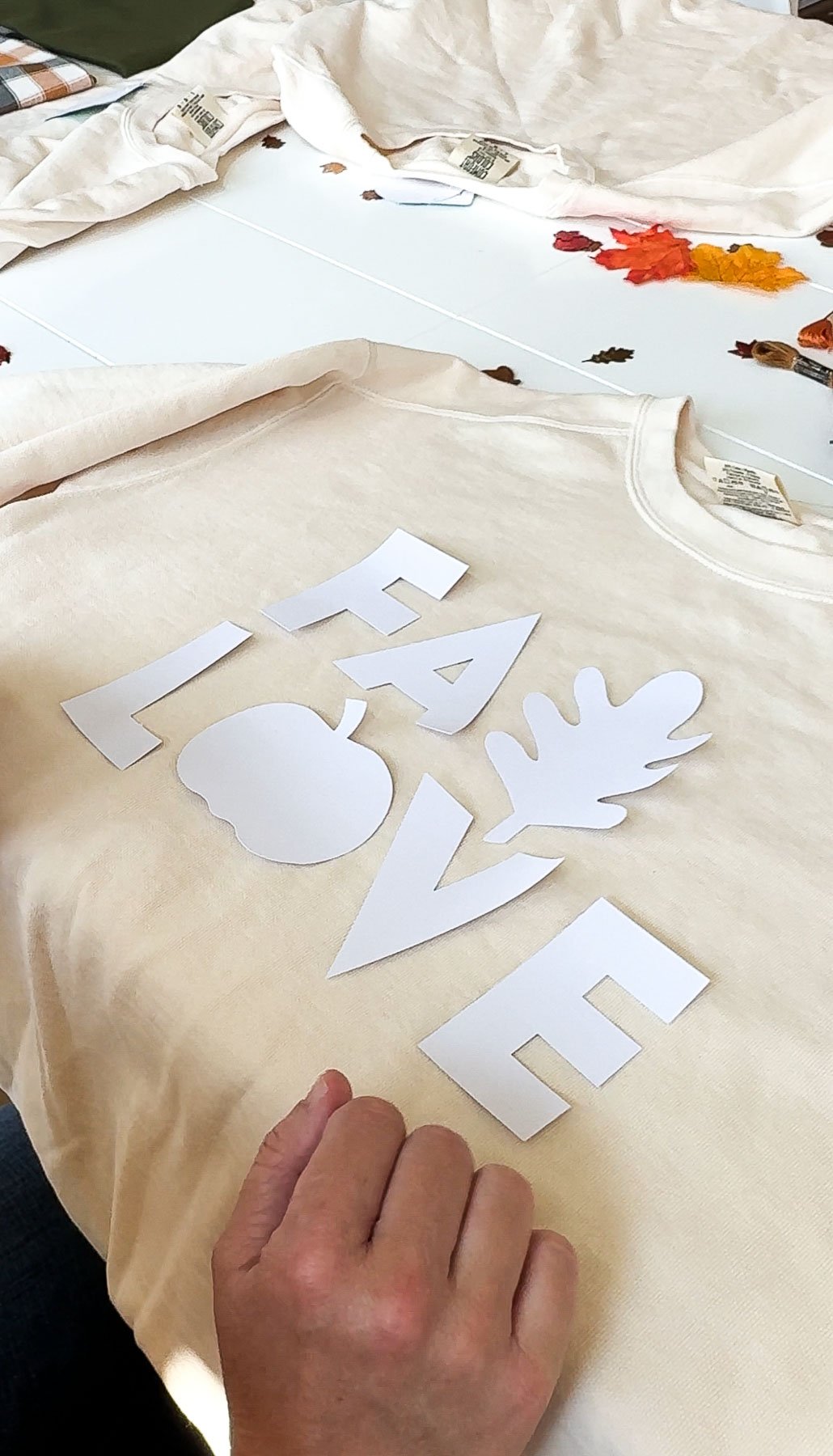 letter cutouts on a cream sweatshirt