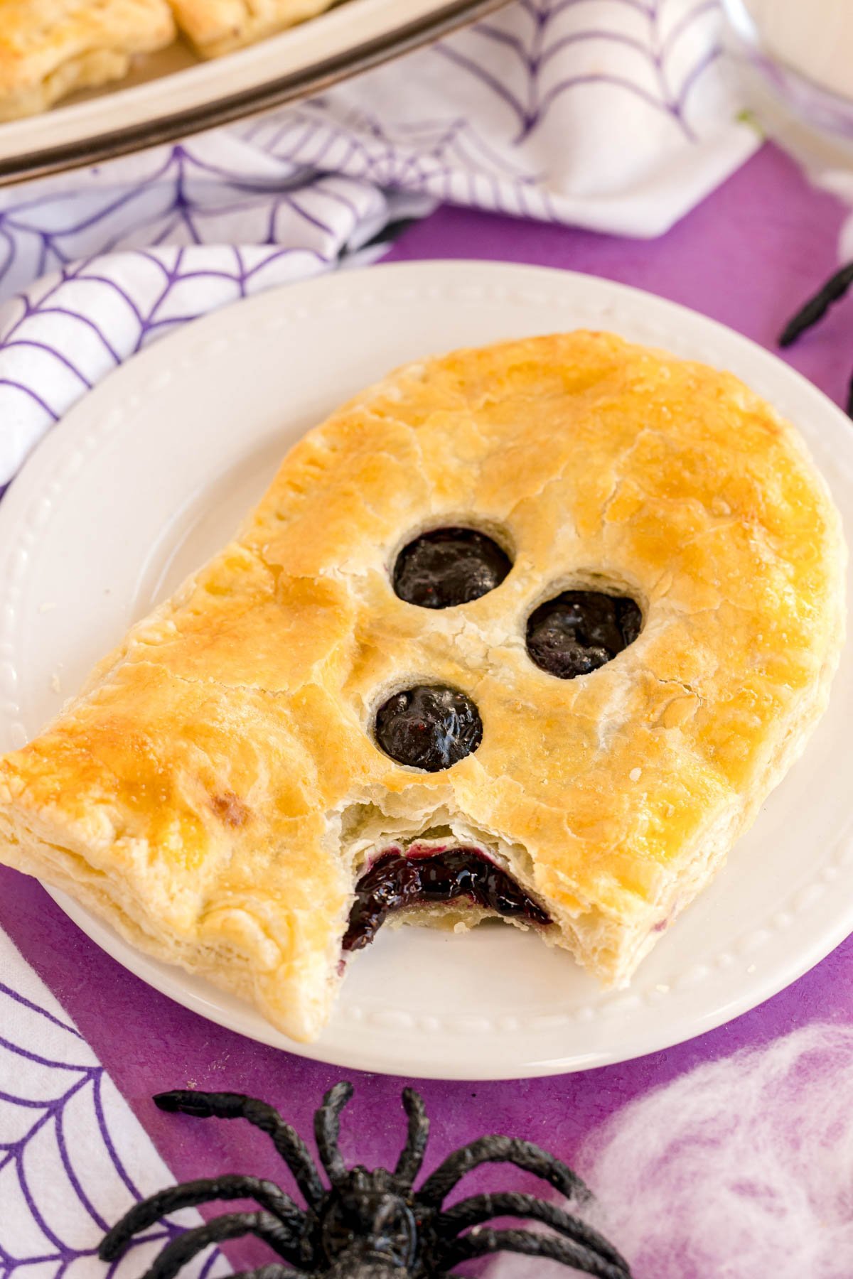 ghost shaped strudel on a white plate with a bite out of it