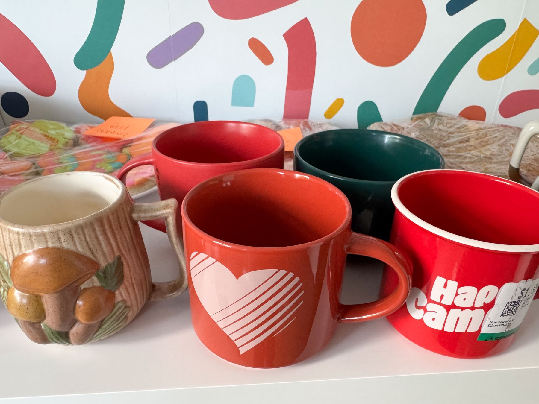 a bunch of thrift store mugs on a white desk