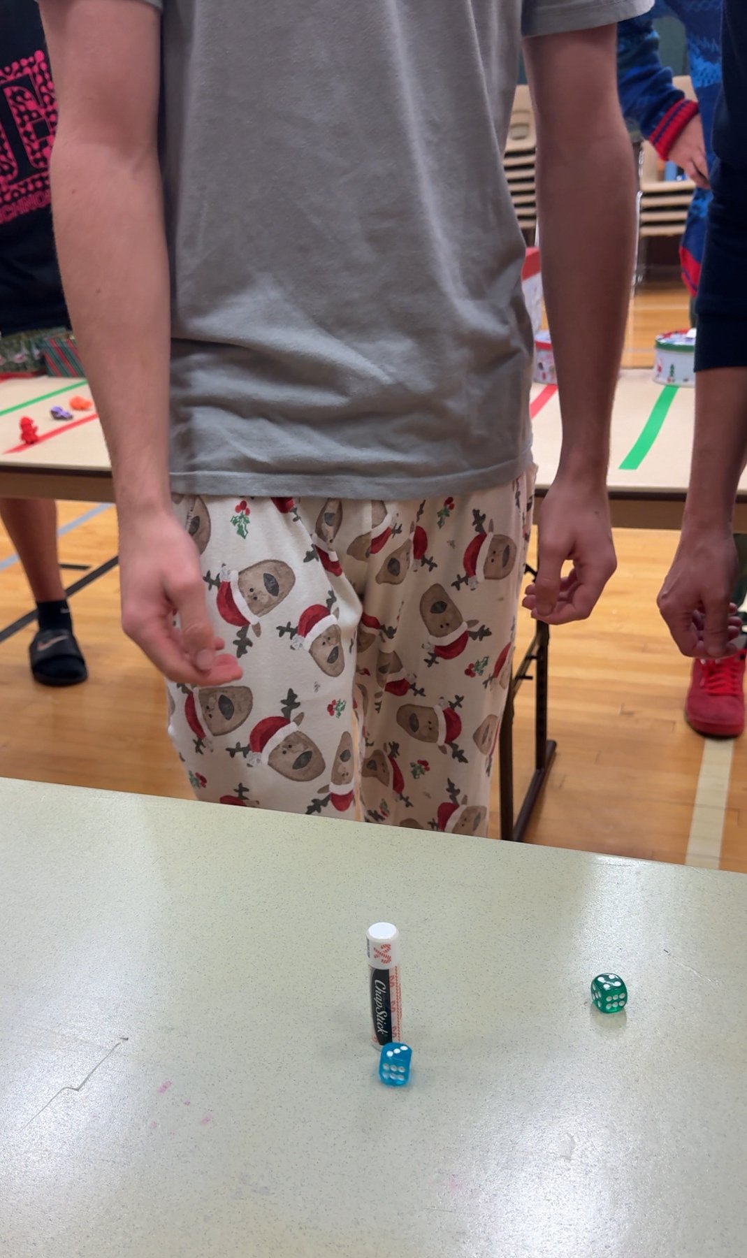 teen boy standing next to a table with chapstick