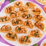 tomato balsamic bruschetta on pieces of toasted bread on a white plate