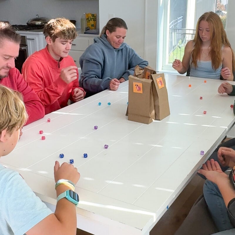 family playing a dice game with turkey bags in the middle
