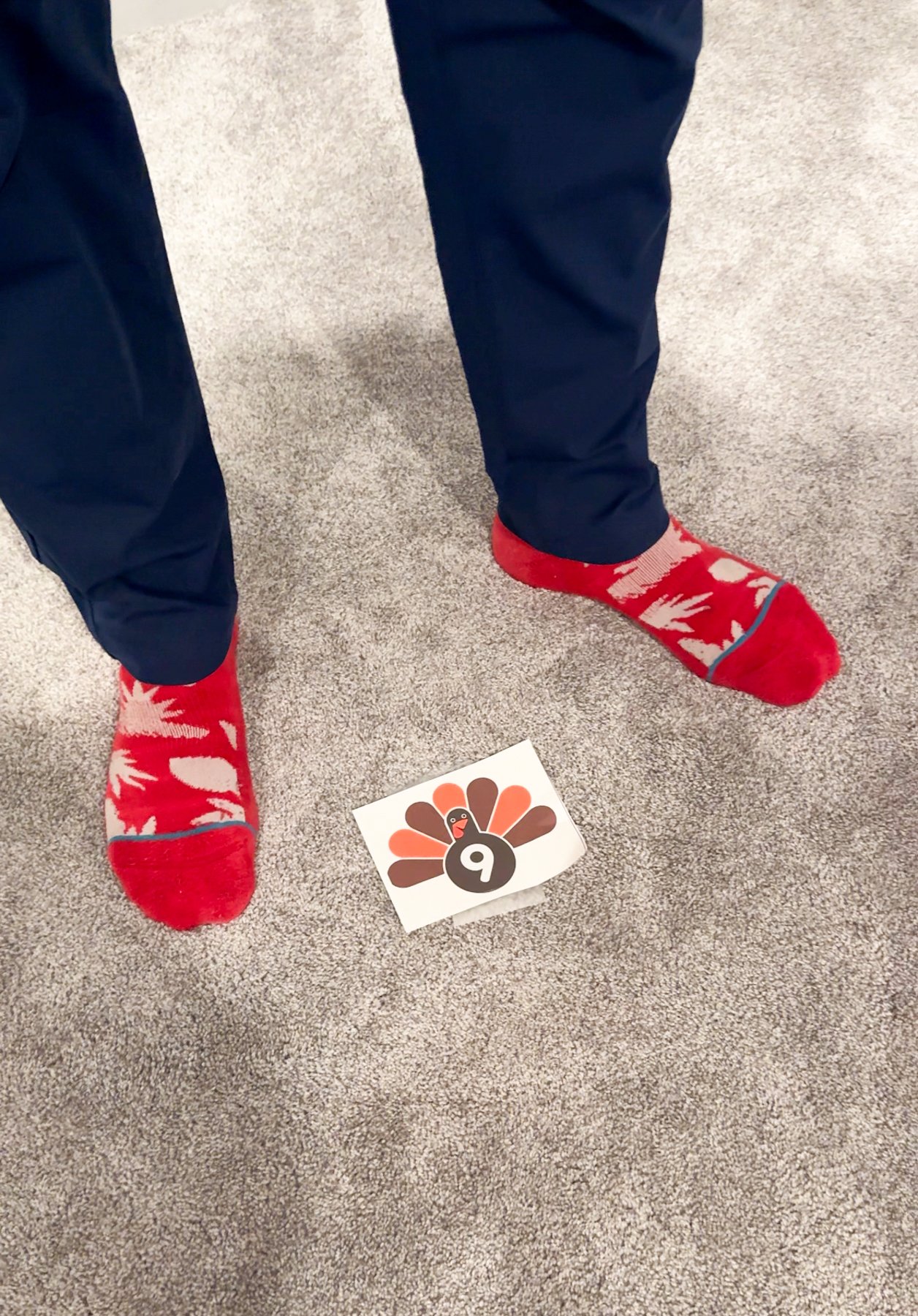 man standing on carpet with a picture of a turkey on the ground