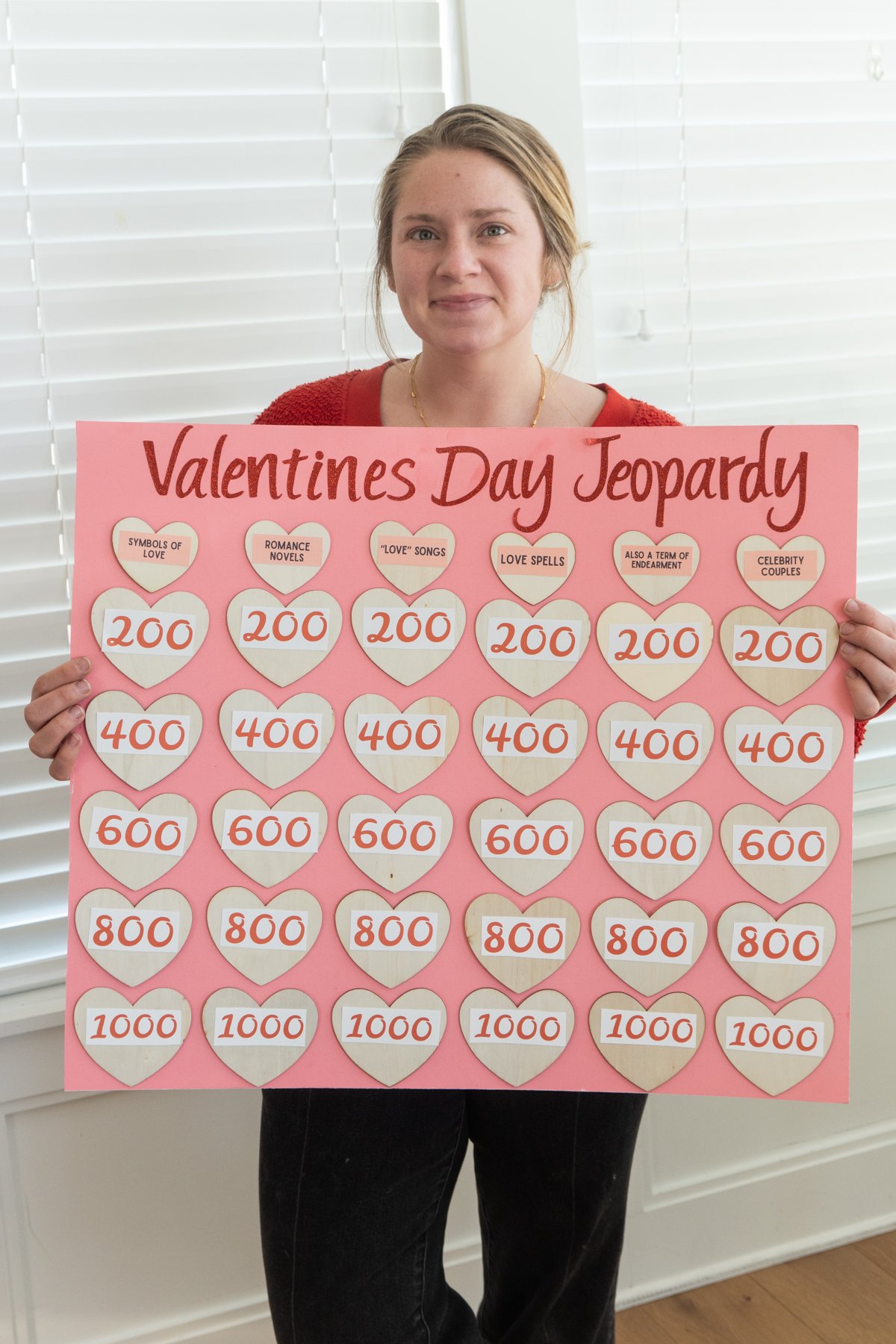 woman holding a Valentine's Day Jeopardy board