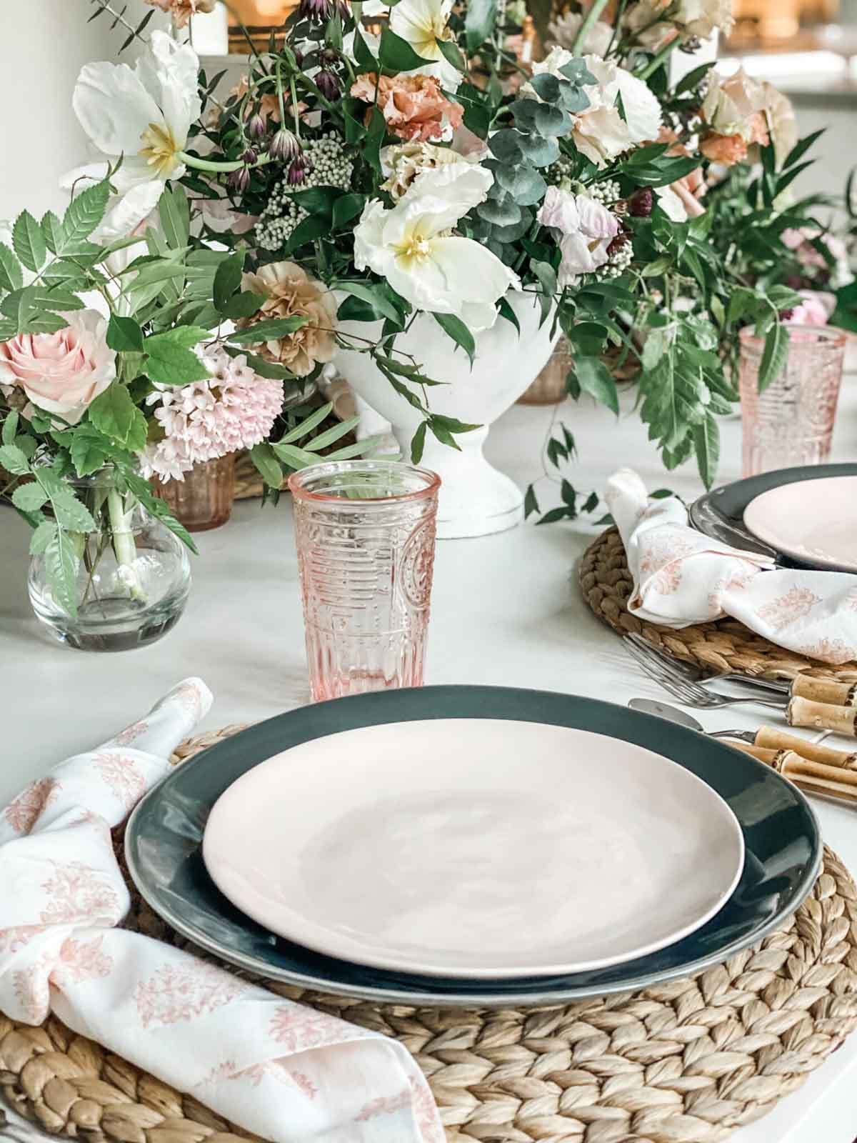 pink and green plates staked with matching dishware on a table