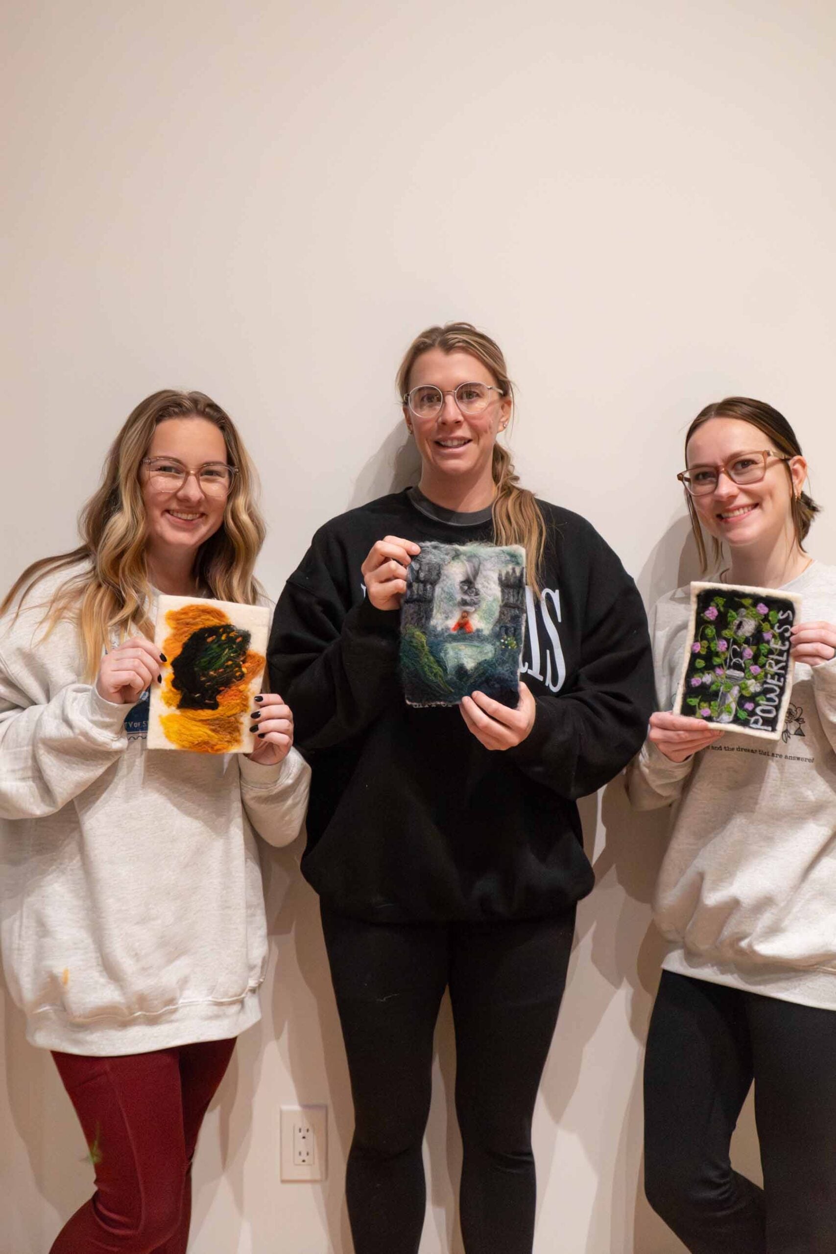 women holding felt book covers