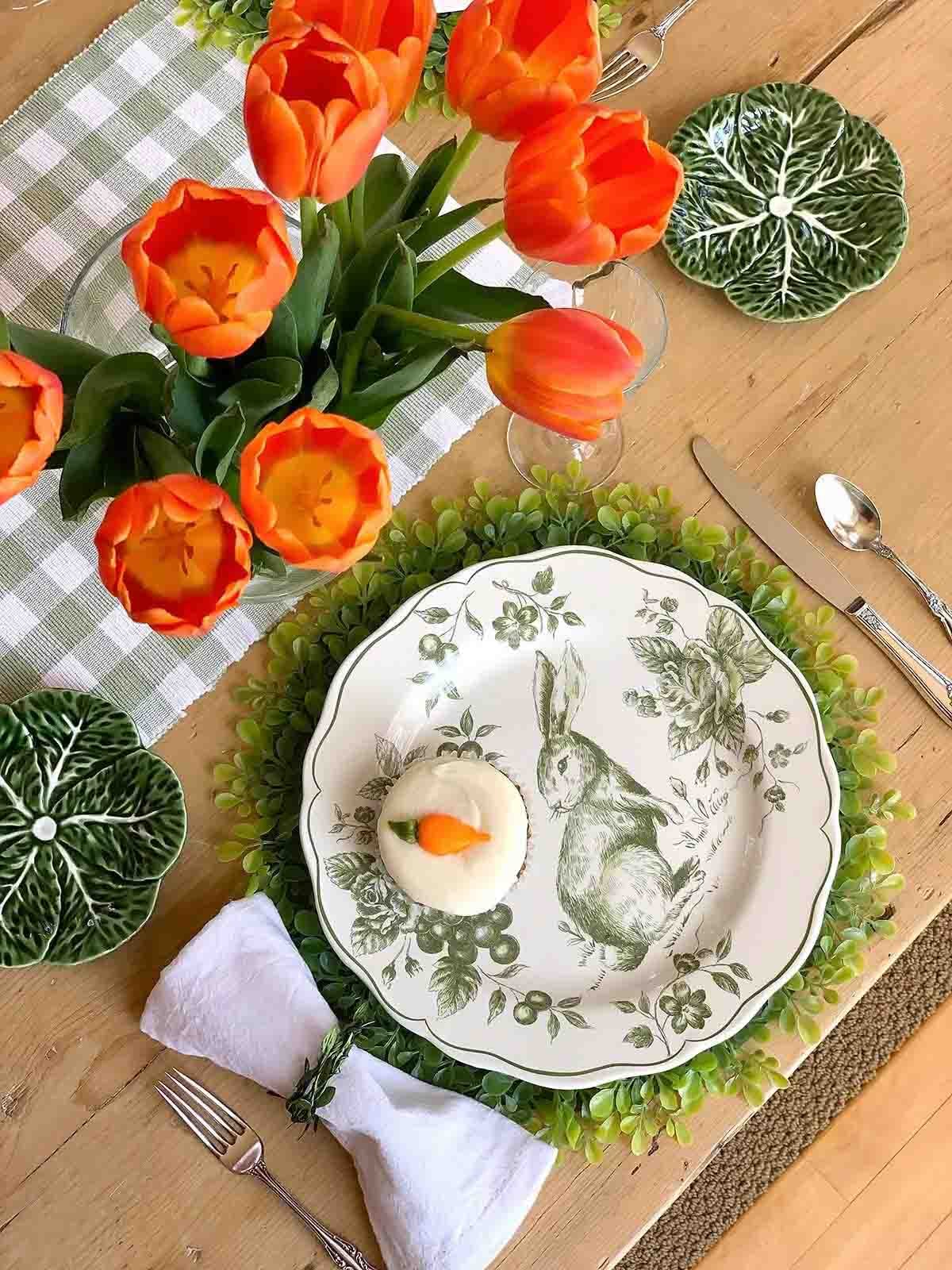 orange tulips on a table with green placemat and side dishes