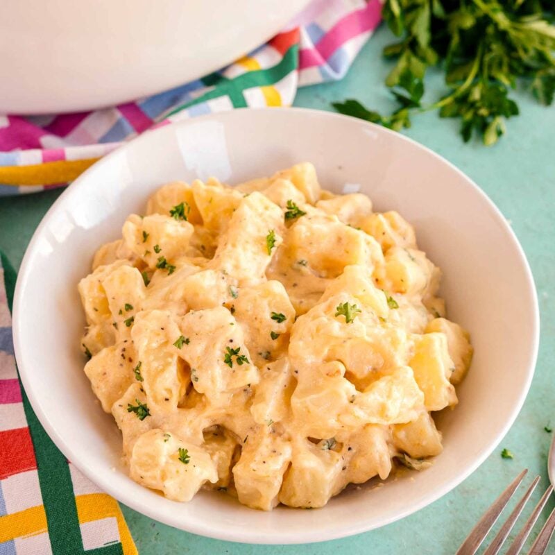 slow cooker cheesy potatoes in a white bowl