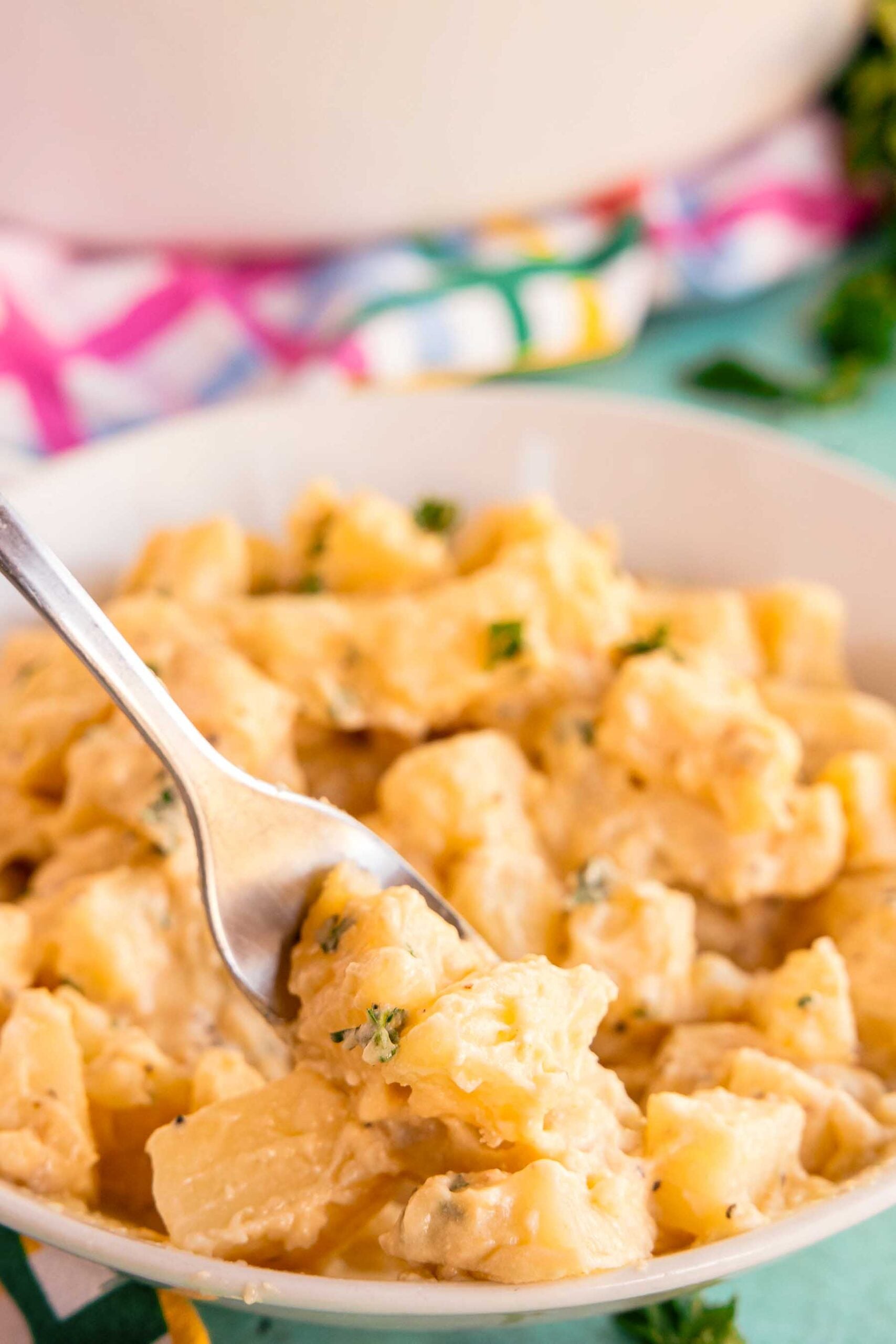 slow cooker cheesy potatoes in a white bowl