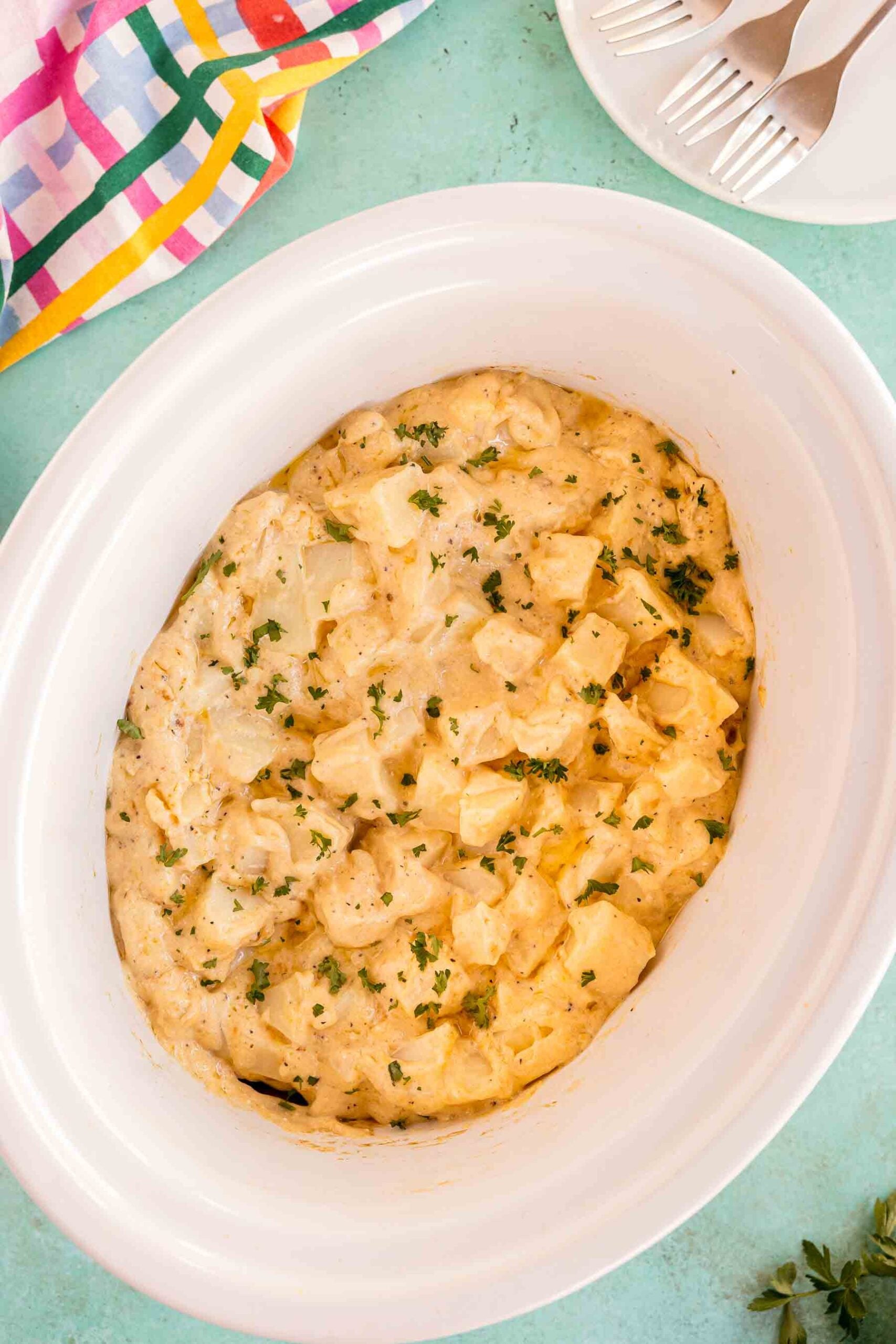slow cooker cheesy potatoes in a white bowl