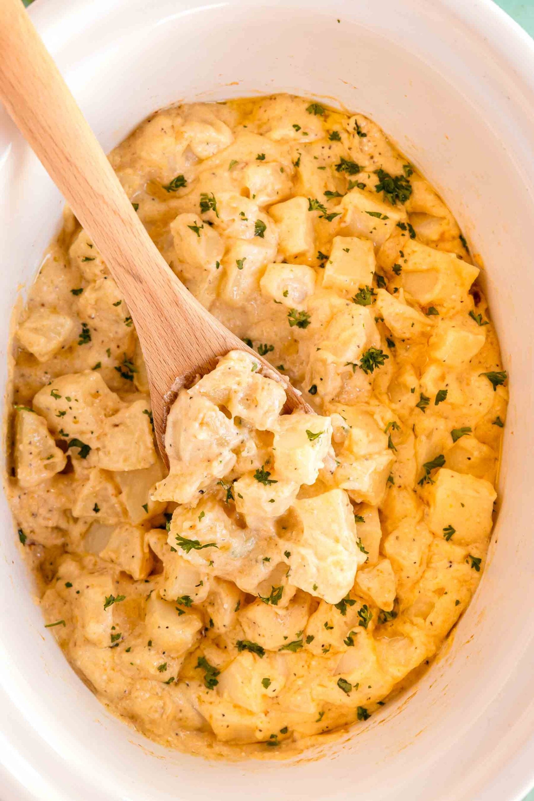 slow cooker cheesy potatoes in a white bowl