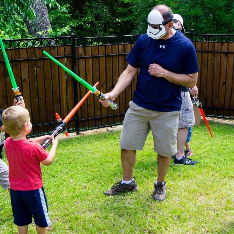 kid and adult fighting with light sabers
