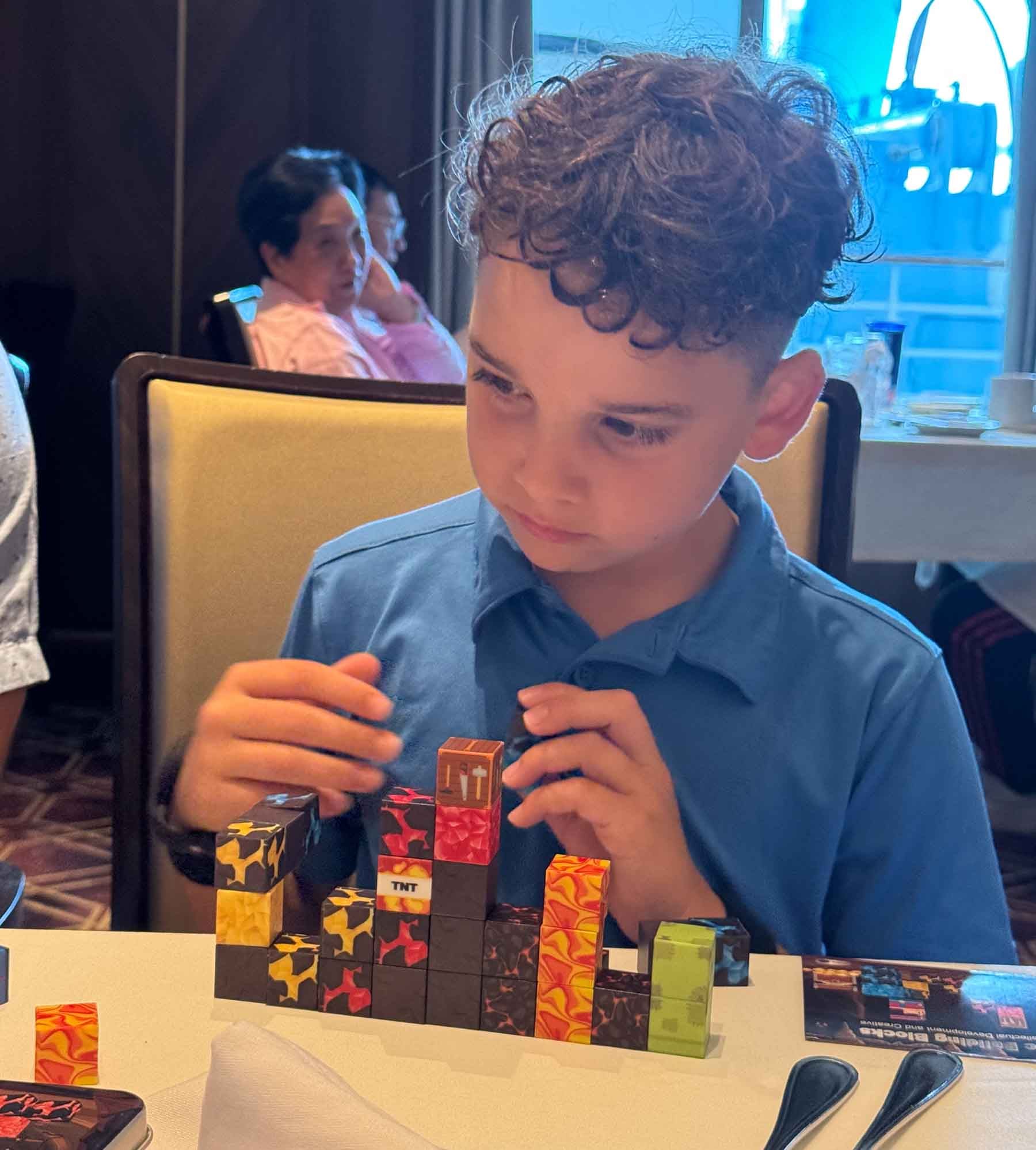 boy building with mini blocks at a cruise table