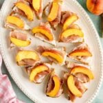 peach prosciutto crostini on a white plate