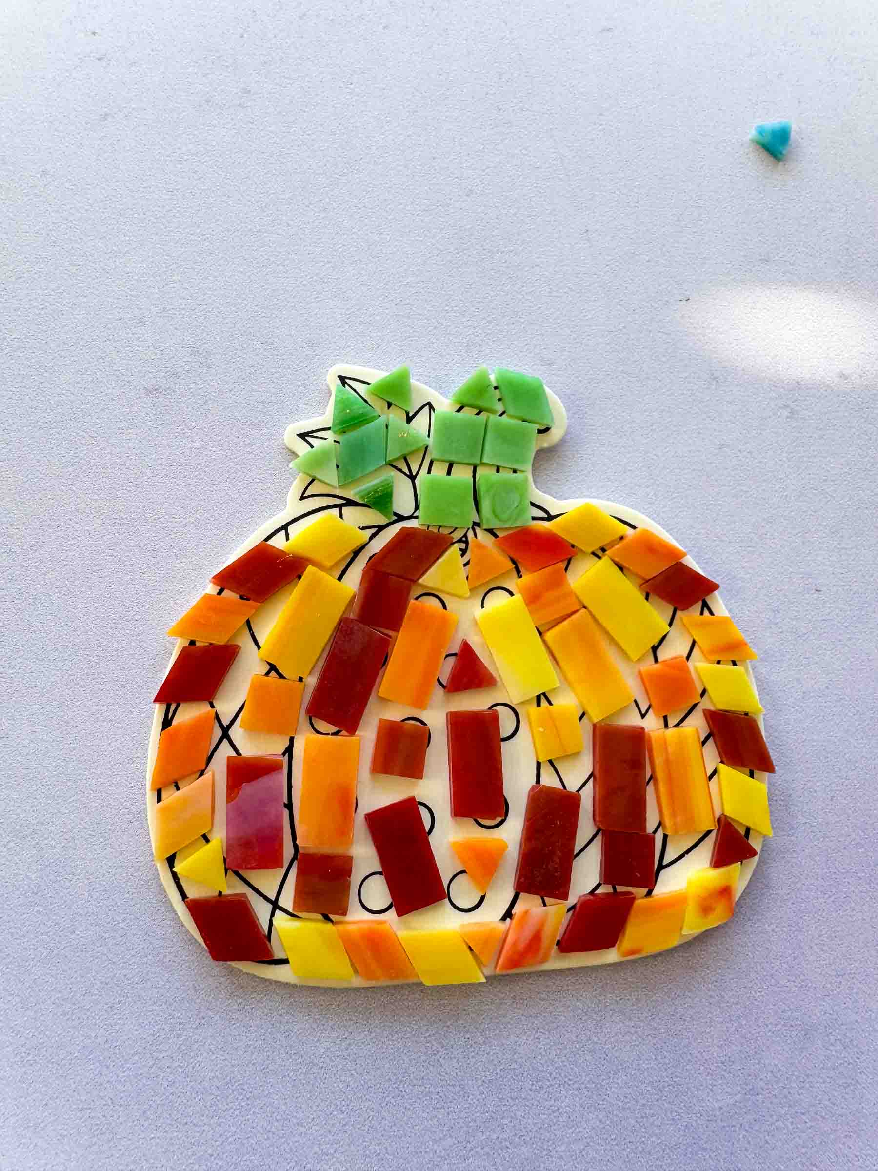 mosaic tiles on a wooden pumpkin